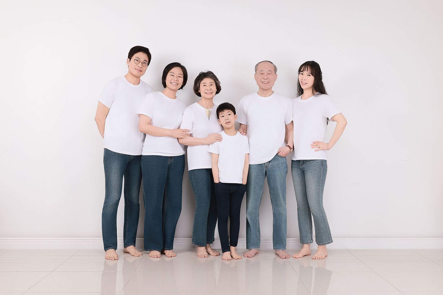 흰 티셔츠와 청바지를 맞춰 입고 맨발로 나란히 선 여섯 사람