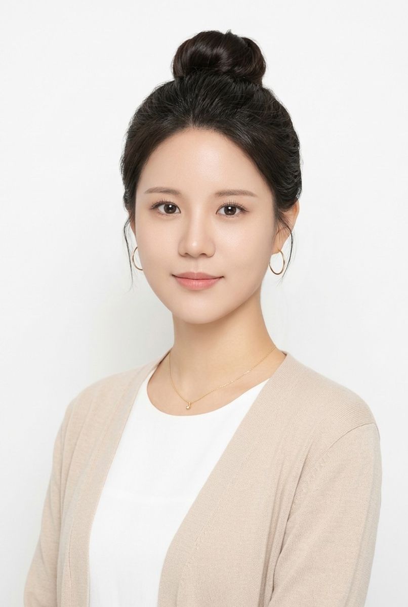 올림머리에 베이지 카디건과 흰 상의를 입은 인물의 흰 배경 증명사진