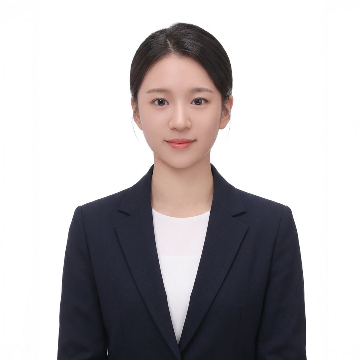 머리를 뒤로 묶고 남색 재킷과 흰 상의를 입은 인물의 흰 배경 증명사진