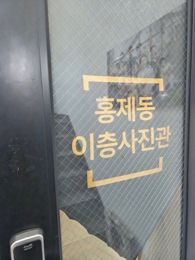 금색 글자로 이층사진관 이름이 붙은 철망 유리 출입문과 도어록