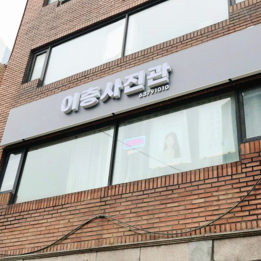 붉은 벽돌 건물 2층 창 위에 걸린 이층사진관 간판과 OPEN 네온사인
