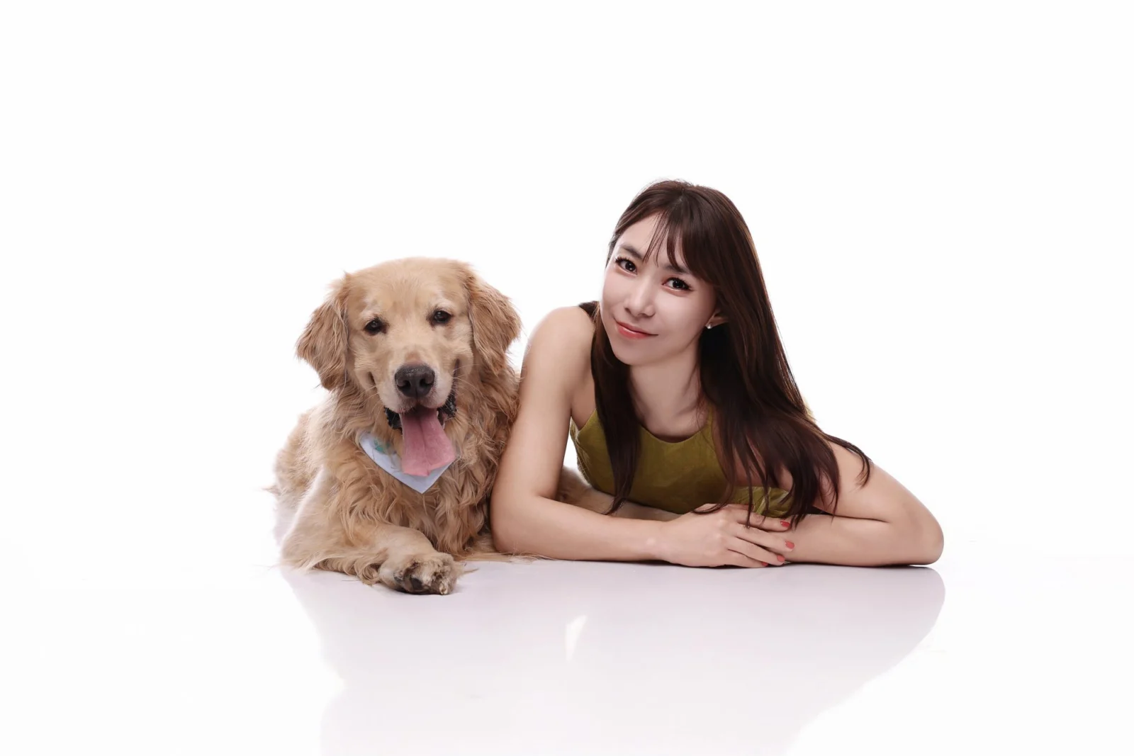 흰 바닥에 엎드린 한 사람 옆에 황금빛 대형견이 나란히 엎드린 둘이함개 사진