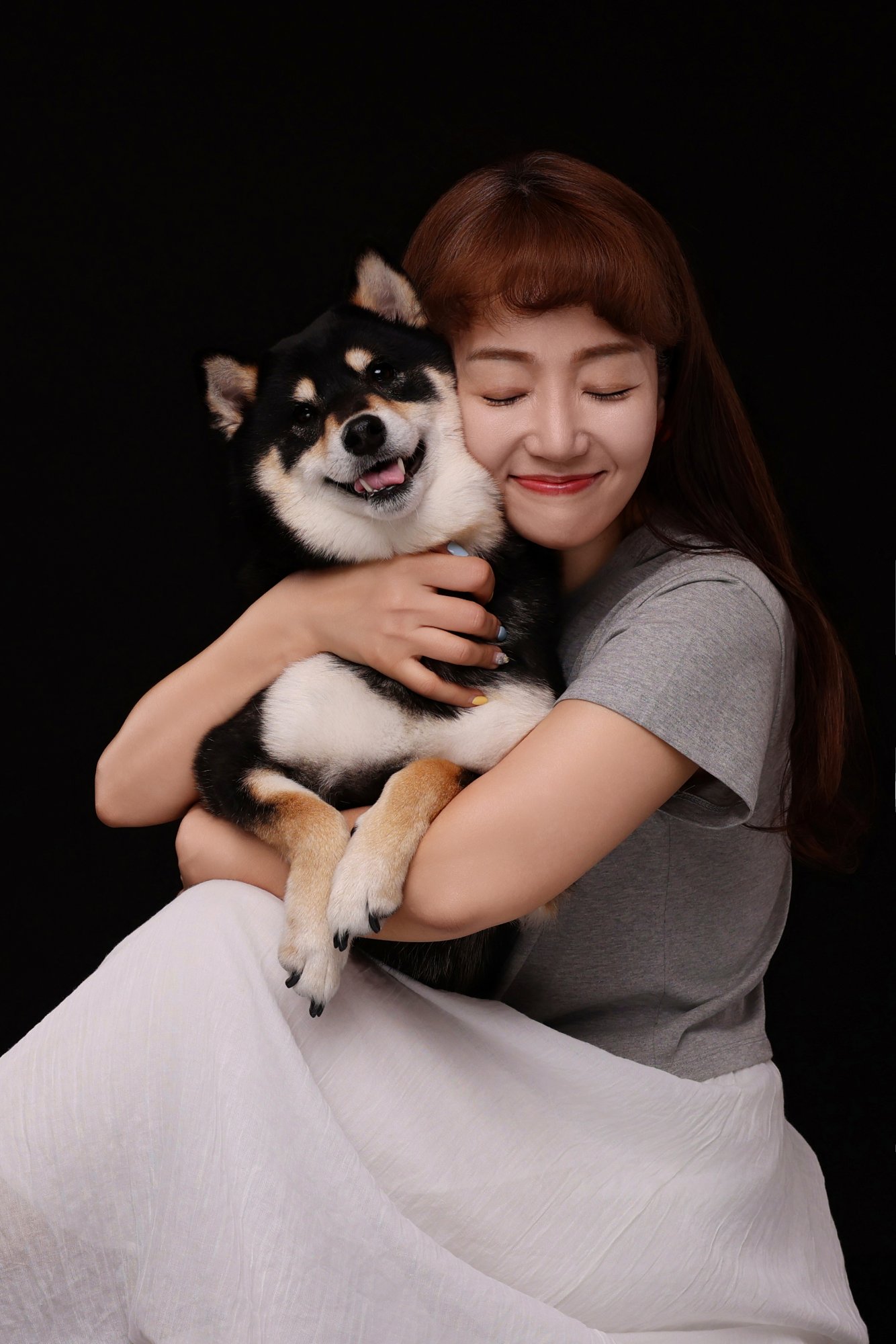 블랙탄 시바견을 꼭 끌어안고 눈 감고 웃는 여성