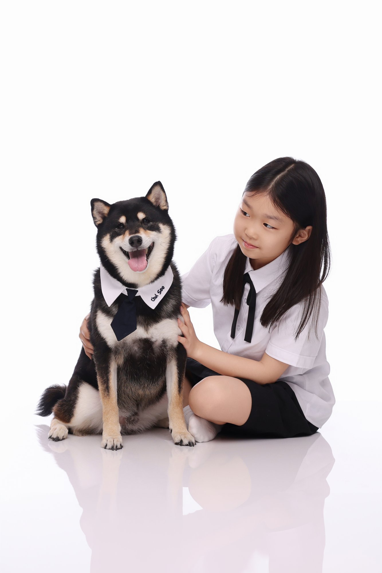 시바견 옆에 앉아 강아지를 바라보는 아이