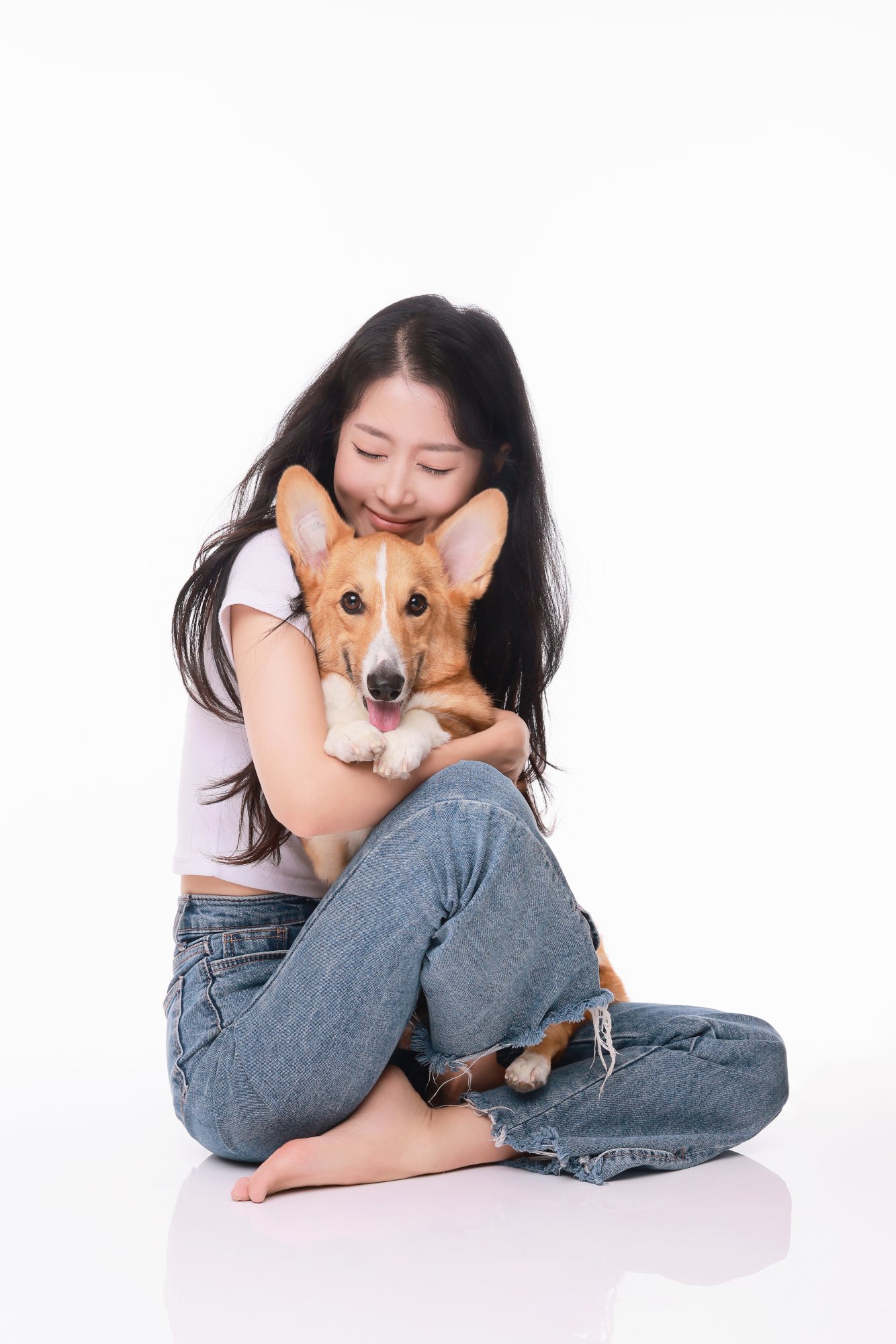 청바지 차림으로 웰시코기를 품에 안은 여성