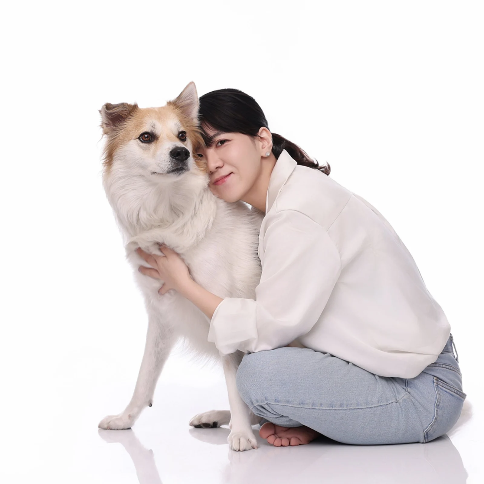 크림색 장모견에게 얼굴을 기대고 앉은 한 사람의 정사각 둘이함개 사진