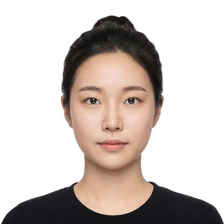 머리를 위로 묶고 검은 상의를 입은 인물의 흰 배경 증명사진